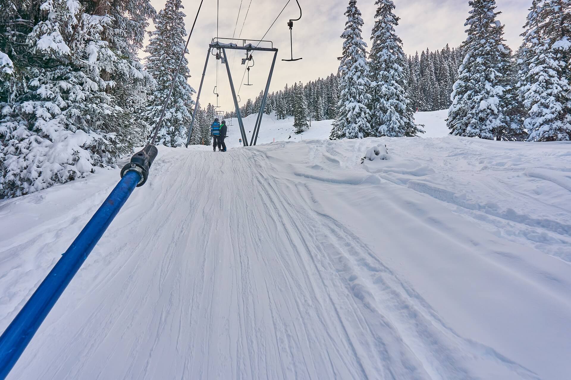 Eine Familie nutzt den Skilift auf einer verschneiten Piste im Allgäu. Der ideale Start in einen erlebnisreichen Winterurlaub mit der ganzen Familie.