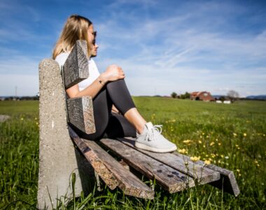 Frau sitzt auf Bank in der Natur und genießt ihr Wanderwochenende Allgäu